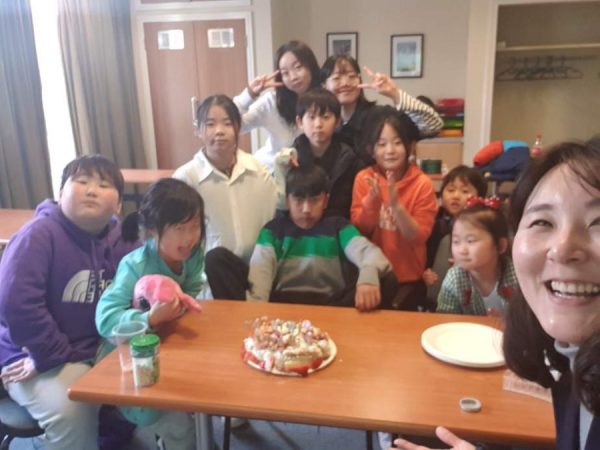 A group of Korean children smiling at the camera, led by So Young.