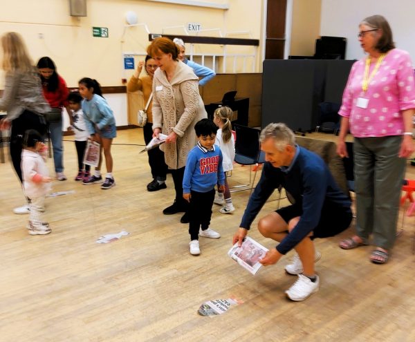Image of older and younger people playing together in the church hall 
